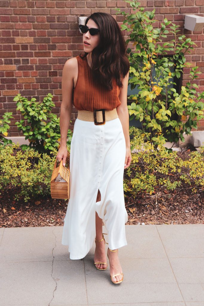 Girl wearing a white skirt wearing a cult Gaia bag
